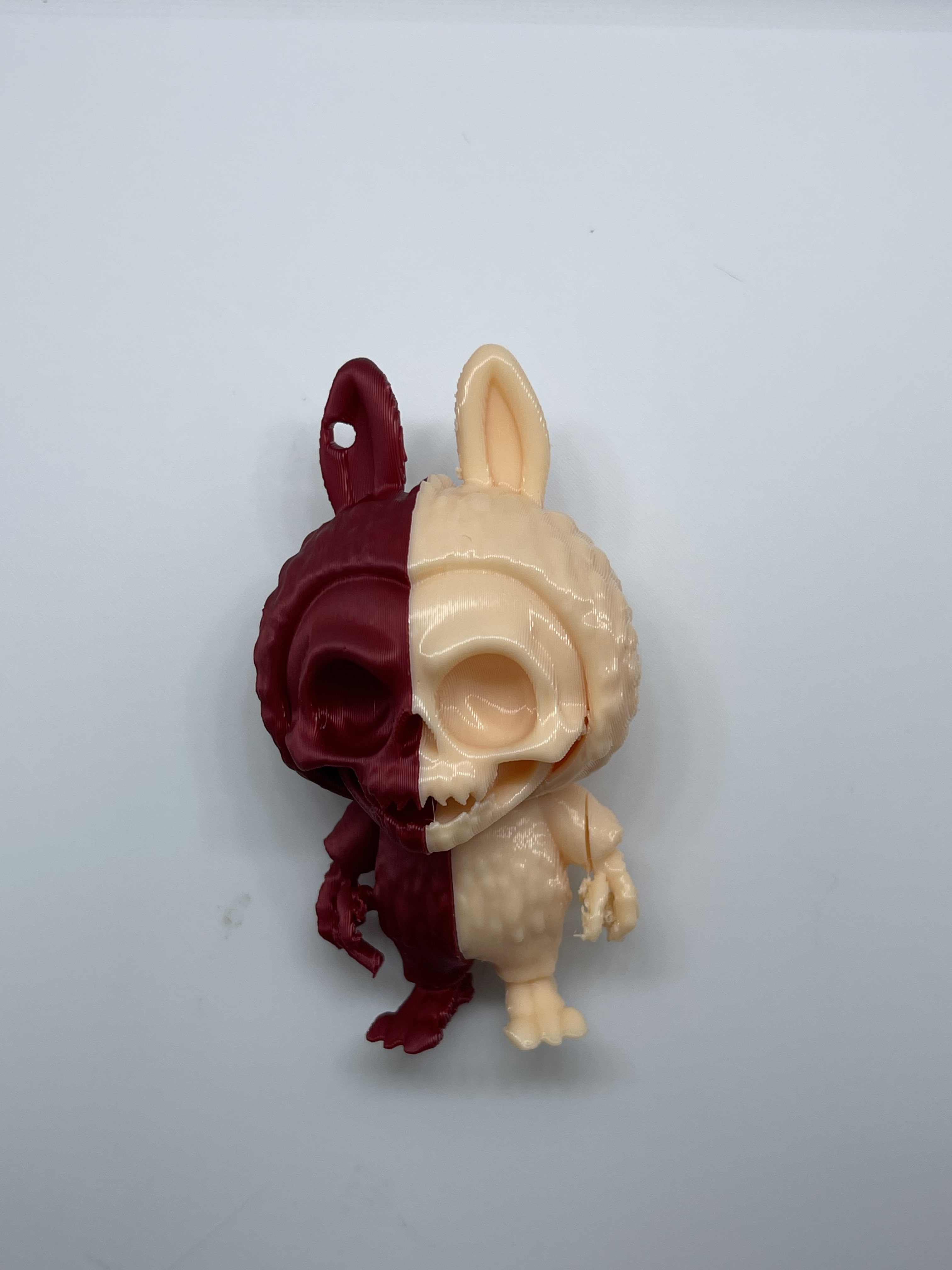 half dark red and half tan labubu keychain with skeleton face and hands